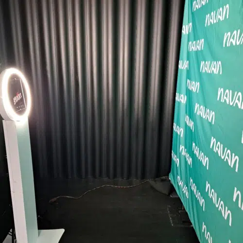 Magic Smiles digital selfie photo booth with ring light and branded NAVA backdrop at a corporate event