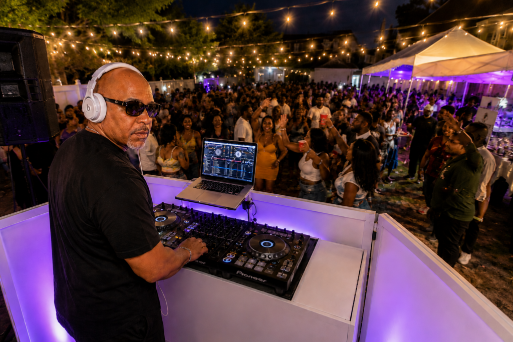 DJ Magic Mixx performing at an outdoor party in Queens NY with a packed dance floor.