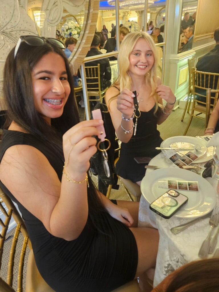 Guests holding custom photo booth keychains at NYC event